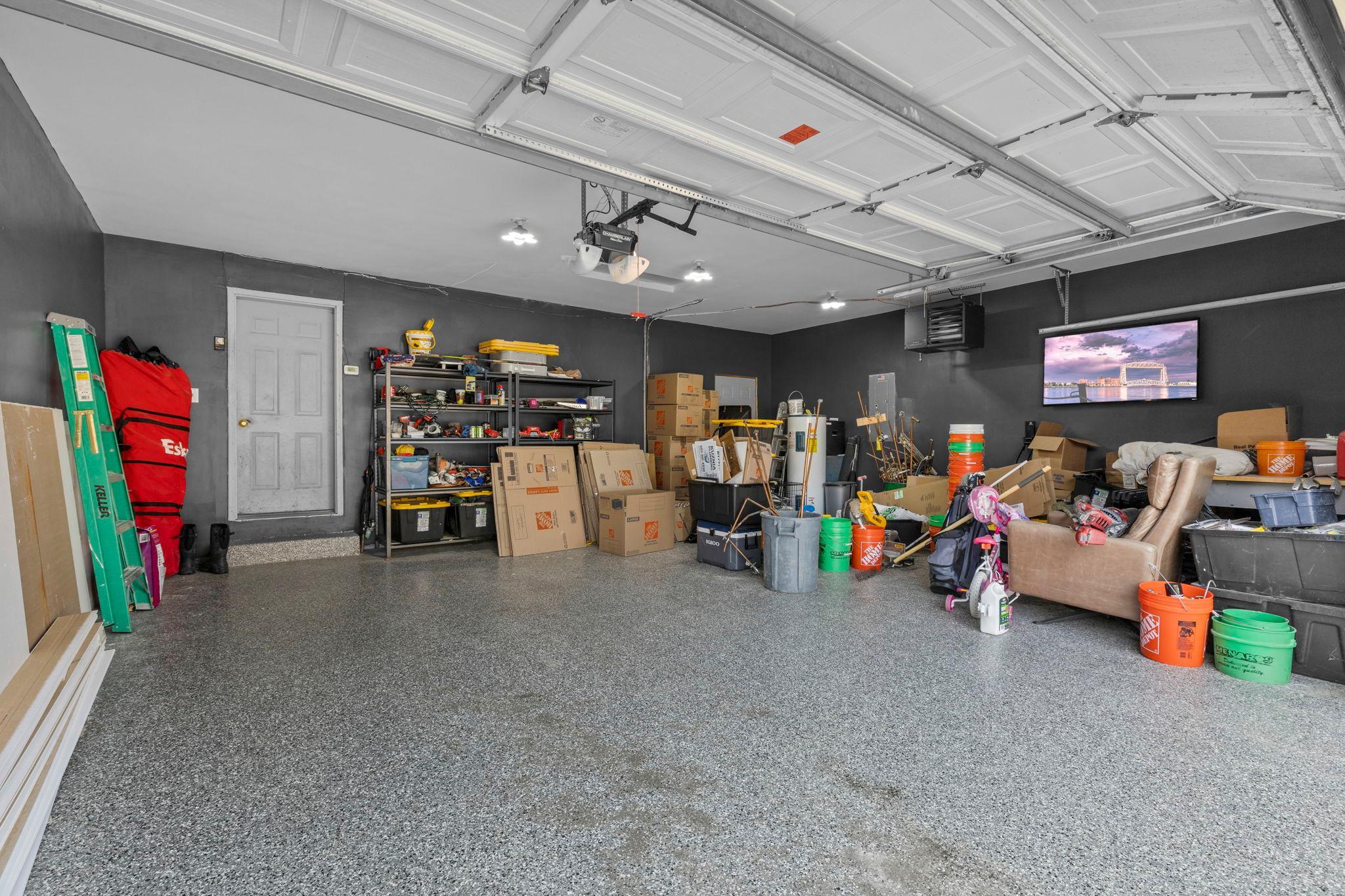 The heated, insulated, and finished garage is a standout feature with durable epoxy floors and plenty of room for vehicles, storage, and projects