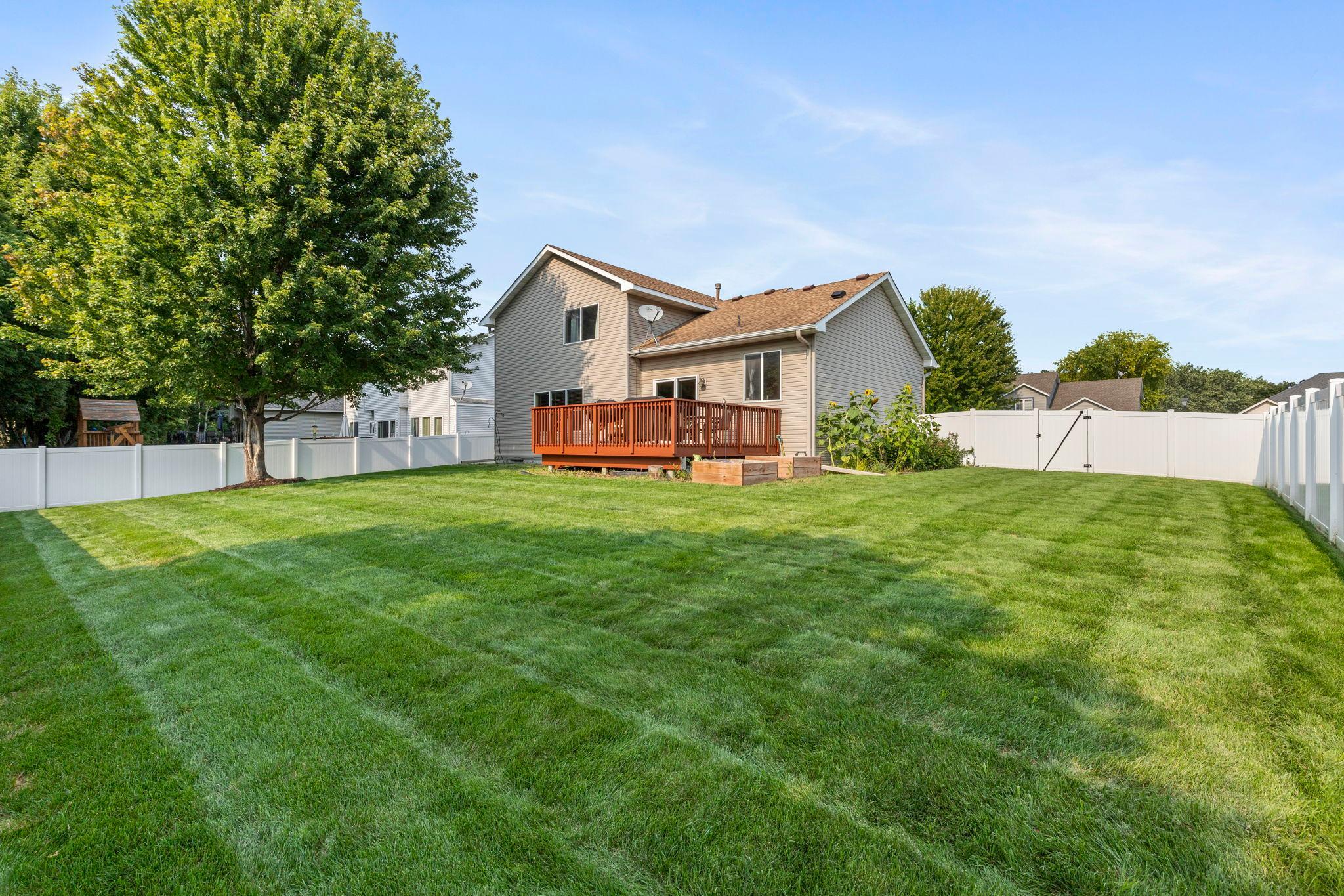 A spacious fully fenced backyard with plenty of green space for kids, pets, gardening, and outdoor fun