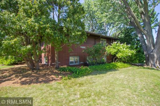 View of east side of home. Brick, stone, and redwood siding. Huge, nicely landscaped lot.