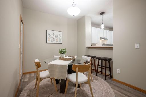 The spacious dining area with an adjacent kitchen breakfast bar providing additional seating for quick meals, morning coffee, or visiting with guests while preparing dinner.