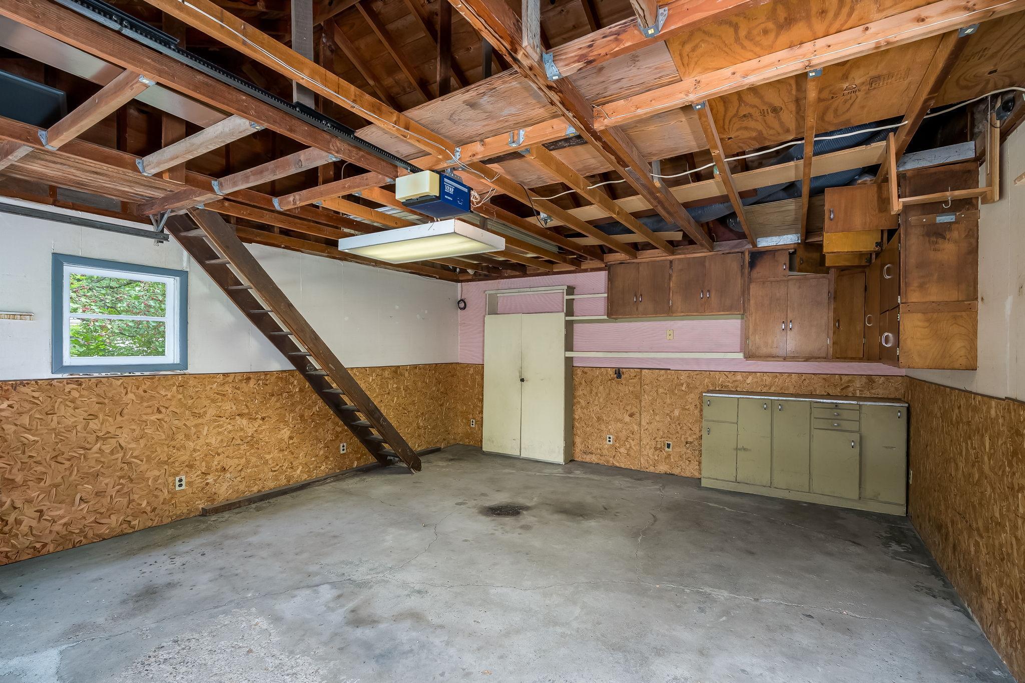 Two car garage with cabinets and more storage above