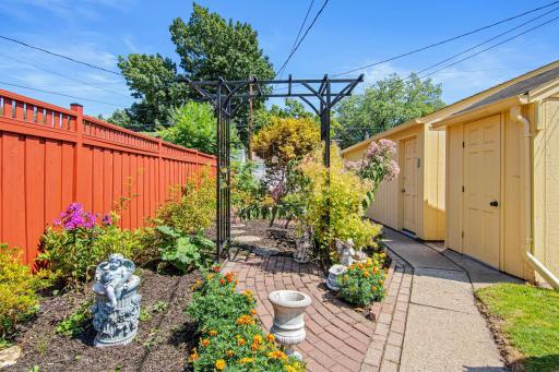 Beautiful garden area with 2-stall garage and additional garden shed