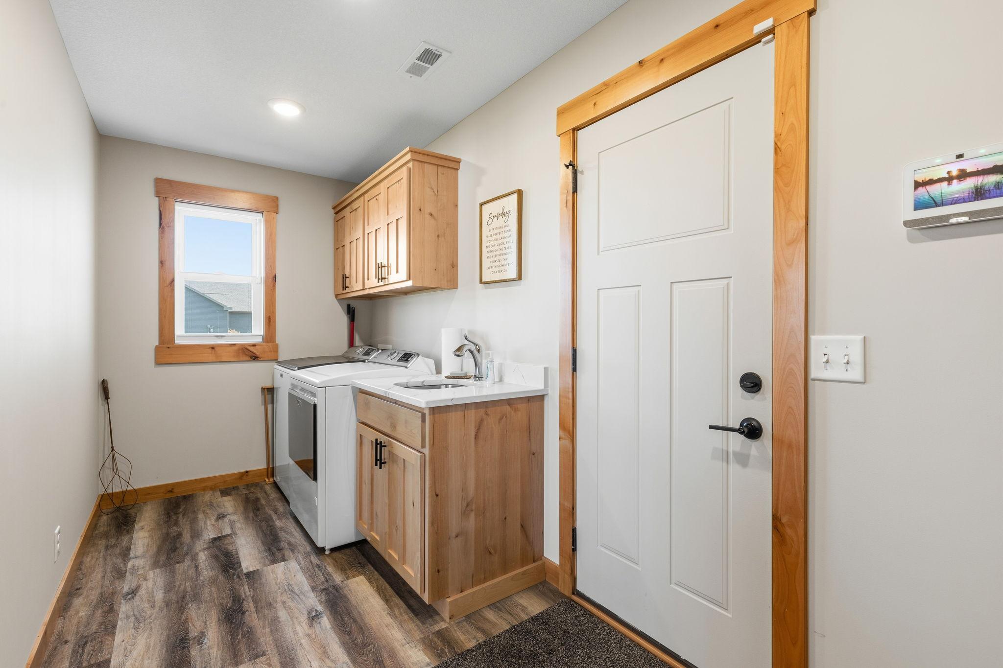 Laundry room at garage entrance has wet sink, cabinets, plus a full wall of locker/hoots/coat or backpack landings. 1895 Otter Way New Richmond-23.jpg