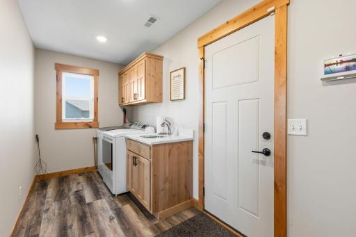 Laundry room at garage entrance has wet sink, cabinets, plus a full wall of locker/hoots/coat or backpack landings. 1895 Otter Way New Richmond-23.jpg
