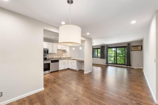 Open concept kitchen/living/dining with view to outside deck