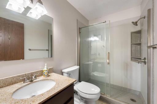 Main condo bathroom with updated granite counters and new walk-in shower