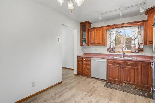 Additional kitchen view highlighting storage, workspace, and updated flooring.