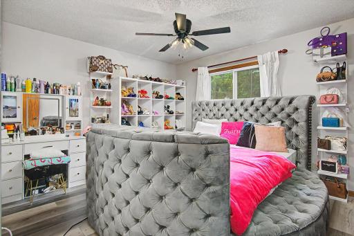 Spacious main-level bedroom with ceiling fan and ample room for furnishings.