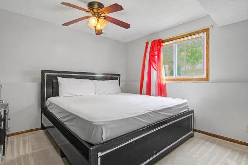 Comfortable lower-level bedroom with ceiling fan and natural light.