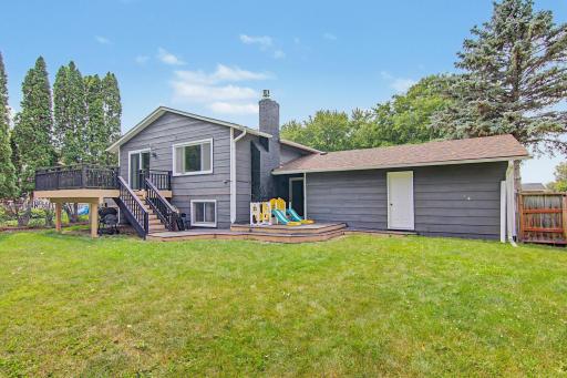 Freshly painted rear exterior with multiple outdoor gathering areas and direct backyard access.