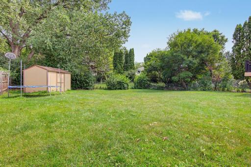 Large backyard surrounded by mature trees, offering plenty of room for outdoor activities.