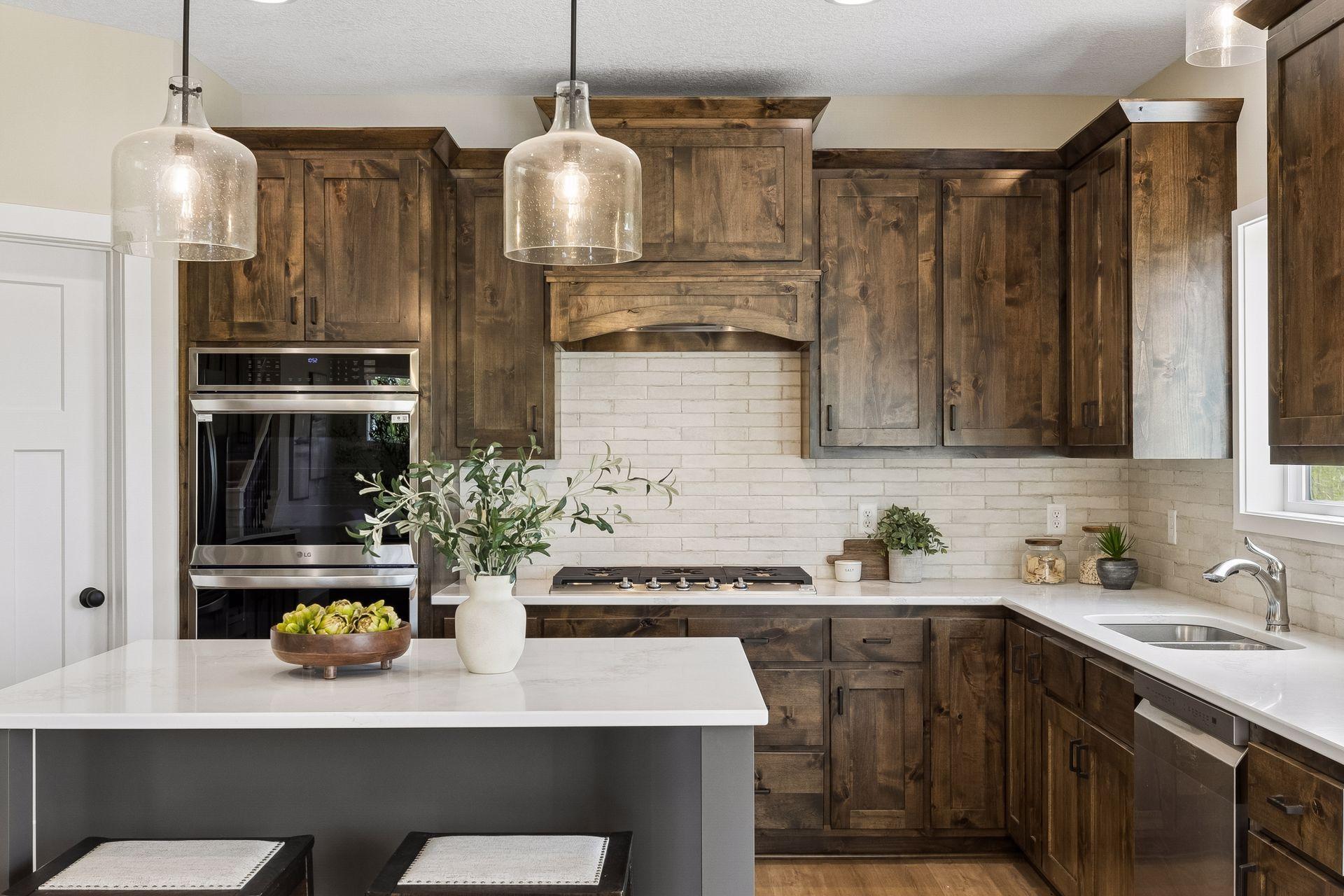 The gourmet kitchen impresses with a center island, cooktop with wood hood, double wall oven, pantry, and abundant cabinet and counter space, including 42” upper cabinets!