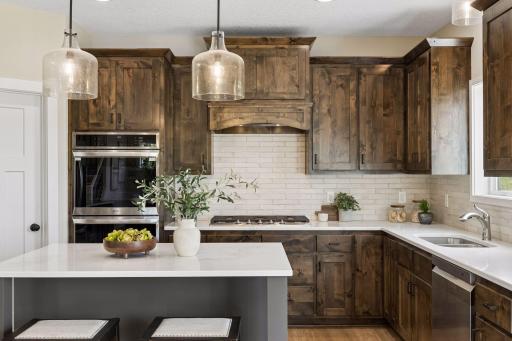 The gourmet kitchen impresses with a center island, cooktop with wood hood, double wall oven, pantry, and abundant cabinet and counter space, including 42â upper cabinets!