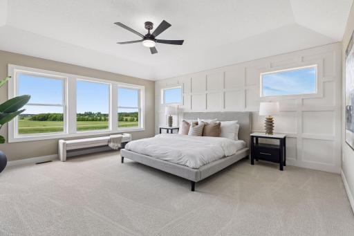 This spacious primary suite features a stylish, on-trend accent wall and beautiful views of the backyard!