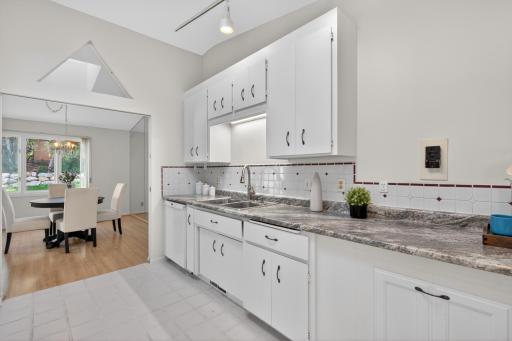 Freshly painted cabinetry with new countertops, sink, and faucet