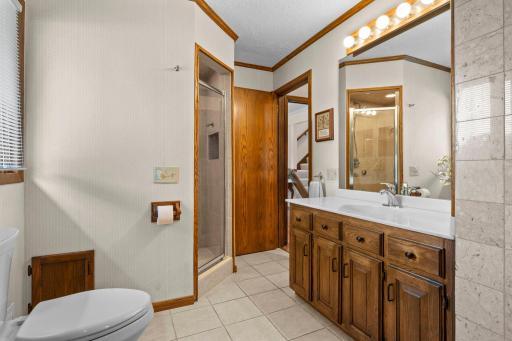 A well-appointed full bath features a long vanity and a step-in glass shower.