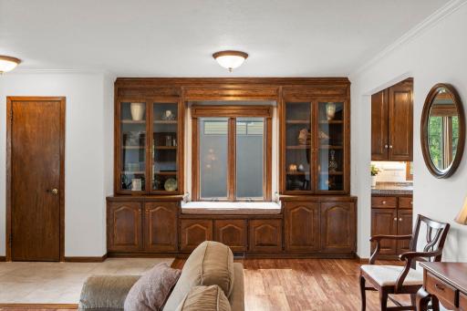 The living room features handsome built-in cabinetry and a cozy window seat, highlighting the home's natural woodwork.