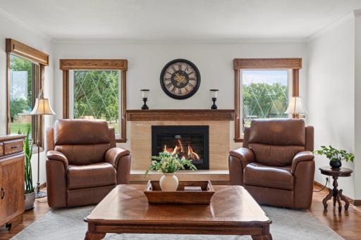 One of three fireplaces warms this cozy family room, with leather recliners and picture windows overlooking the yard.