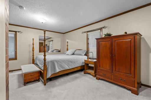 A spacious main-level primary bedroom offers a peaceful retreat with plush carpet and generous furniture space.