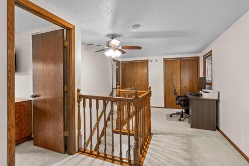 A versatile landing area at the top of the stairs offers flexible space for a home office setup.