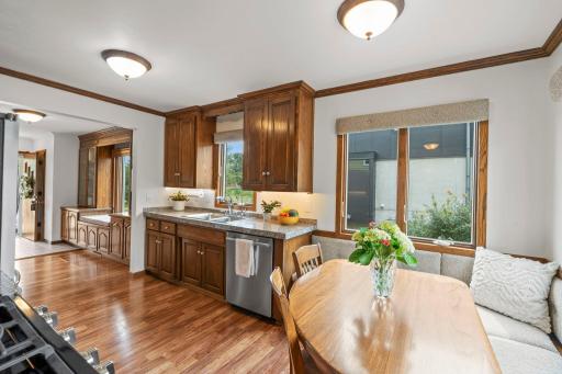 The kitchen's rich wood cabinetry and granite counters pair with a built-in breakfast nook bathed in natural light.