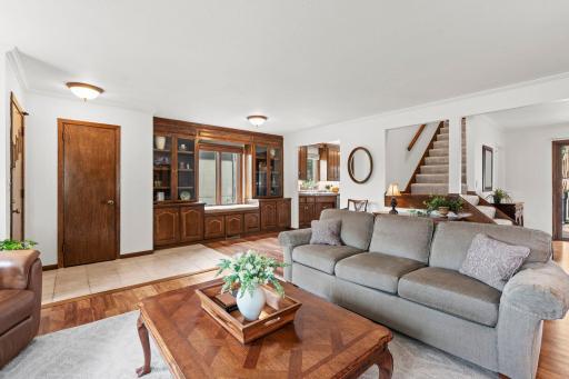 The spacious living room, complete with custom built-ins, offers easy access to the staircase and upper level.