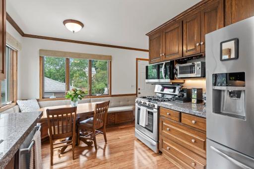 This angle highlights the gas range, updated appliances, and built-in bench seating in the breakfast nook.
