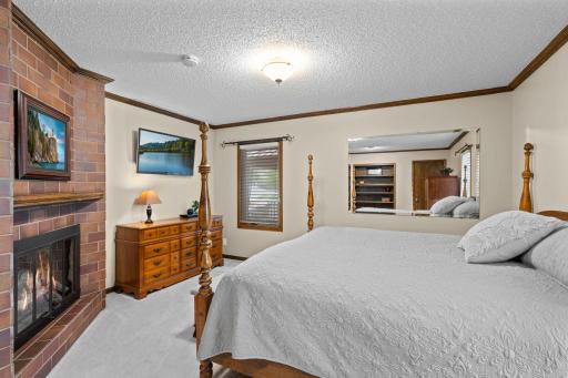 This bedroom's brick fireplace adds cozy character, one of three fireplaces found throughout the home.