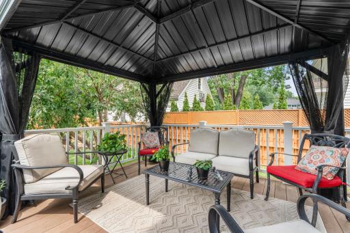 Cozy lounge seating under the gazebo creates an additional outdoor living space on the deck.