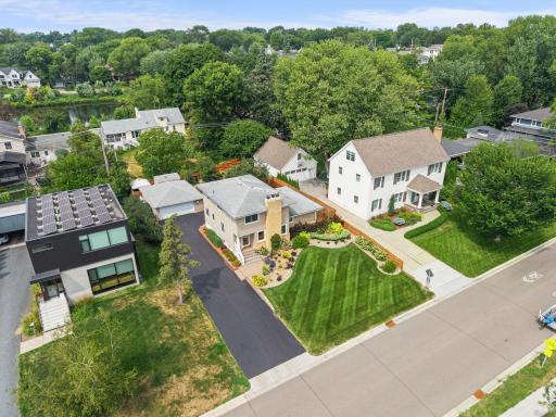Aerial view captures the home's classic lines, wide driveway, and expansive, well-maintained front yard in the heart of Morningside.
