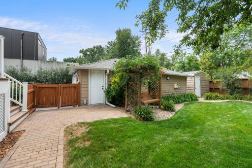 The insulated, heated detached garage sits just beyond a charming pergola and paver walkway.