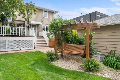 A pergola-covered swing offers a shaded retreat in the backyard, just steps from the deck.