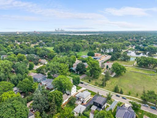 A stunning aerial perspective showcases the neighborhood's tree-lined streets with the downtown Minneapolis skyline on the horizon.