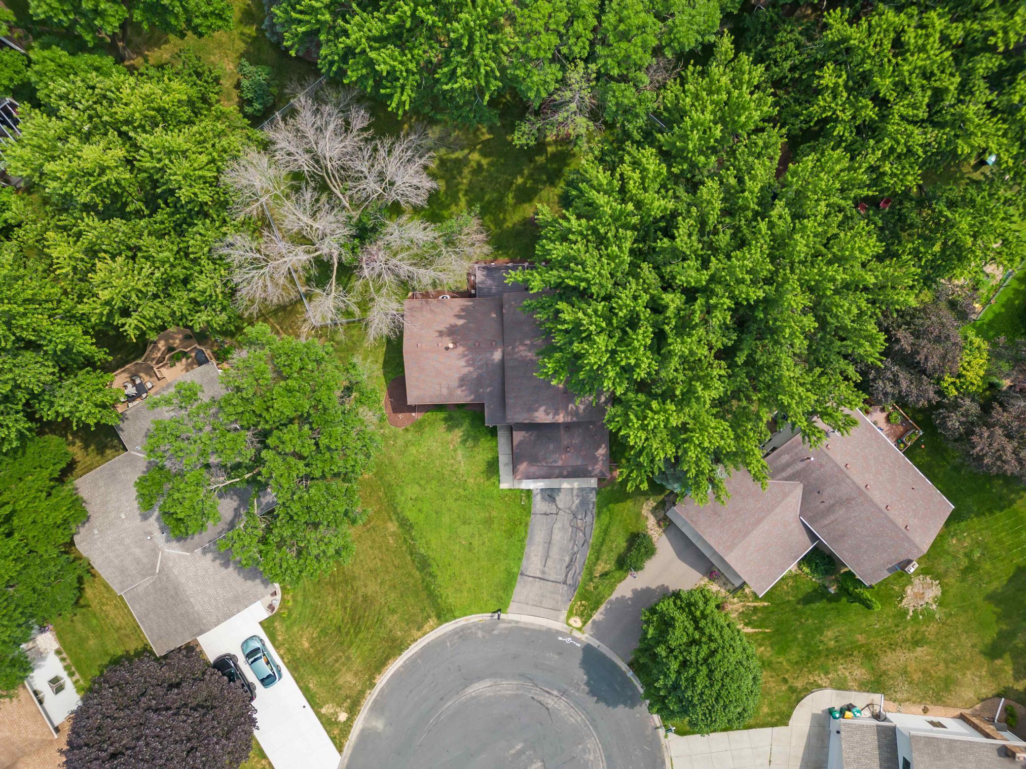 Overhead aerial highlighting the home's cul-de-sac setting, generous yard, mature tree canopy, and surrounding residential neighborhood
