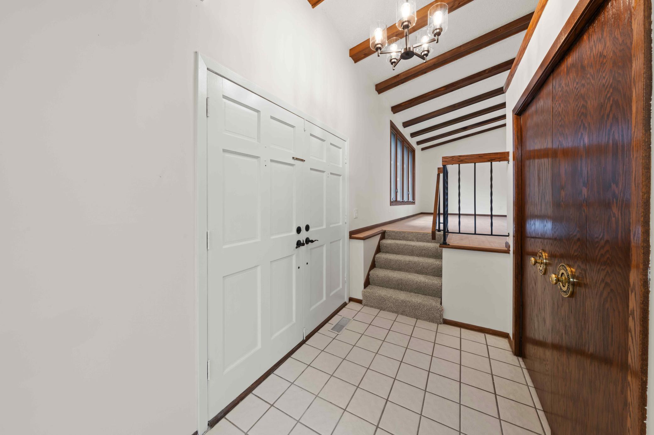 A distinctive entry welcomes you inside with warm wood accents and exposed ceiling beams