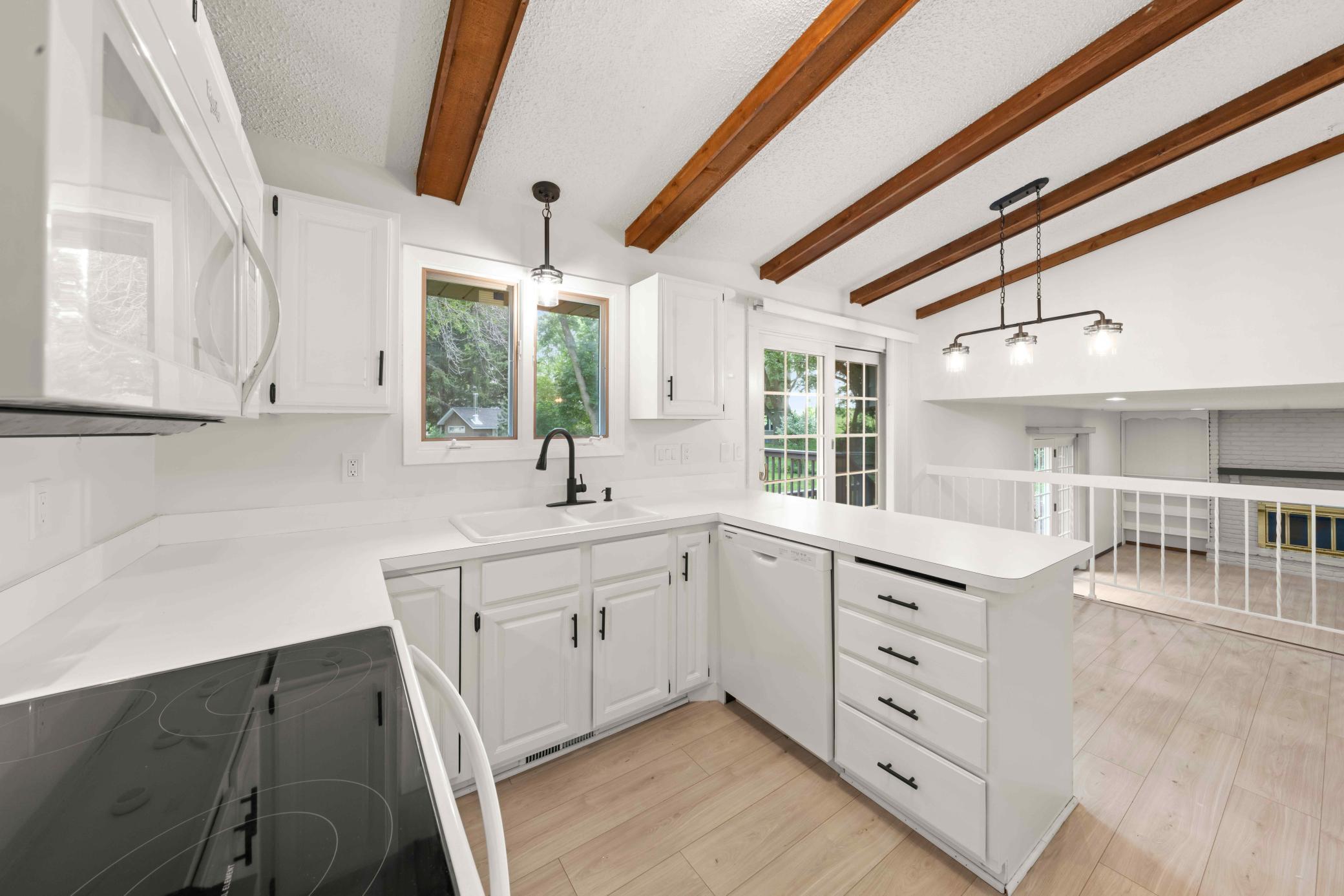 Bright kitchen with generous counter space, white cabinetry and an open connection to the family room