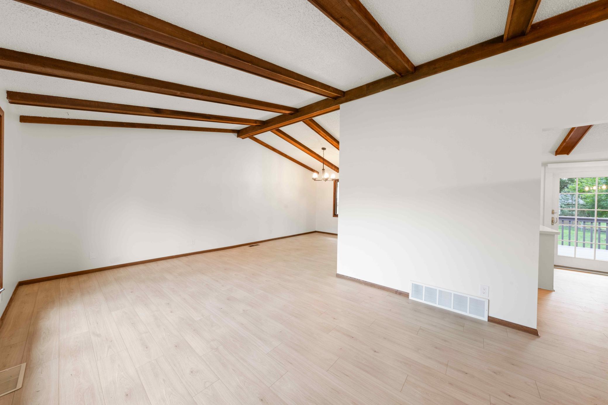Bright, open living areas with updated flooring and beautiful exposed beams throughout