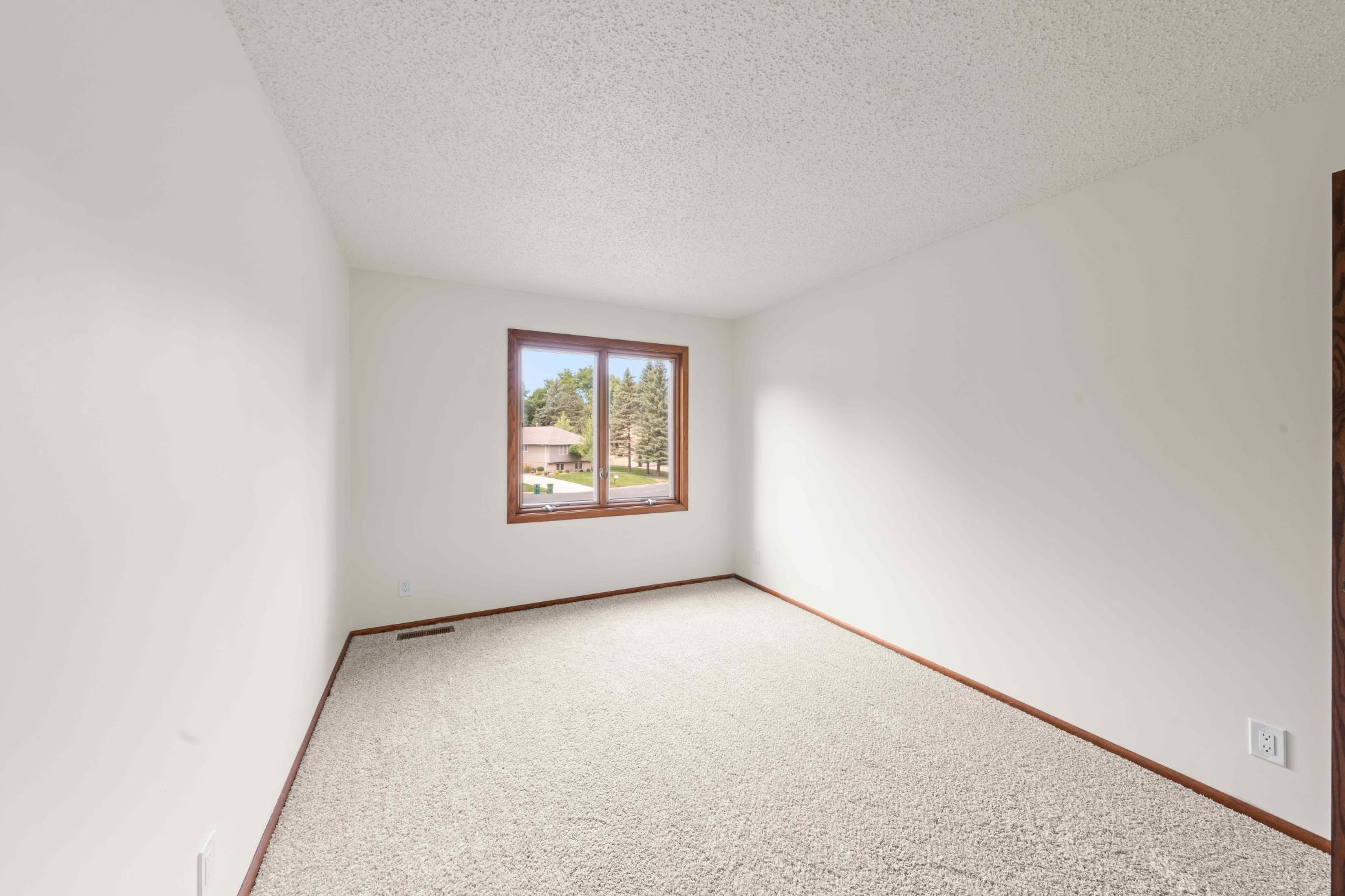 Second bedroom upper-level with new carpeting and a large window