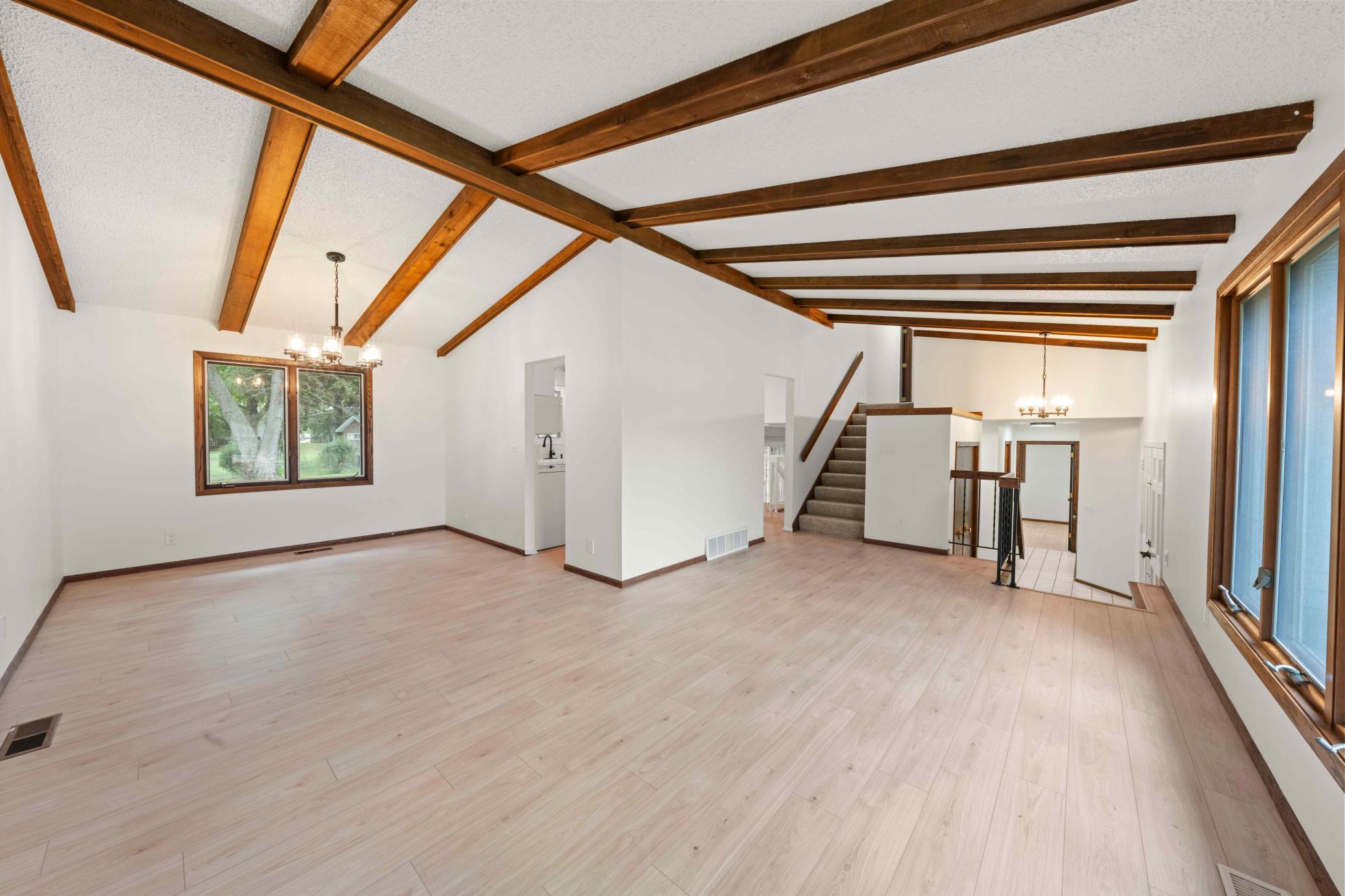 Dramatic vaulted ceilings with exposed wood beams bring warmth and architectural character to the main level