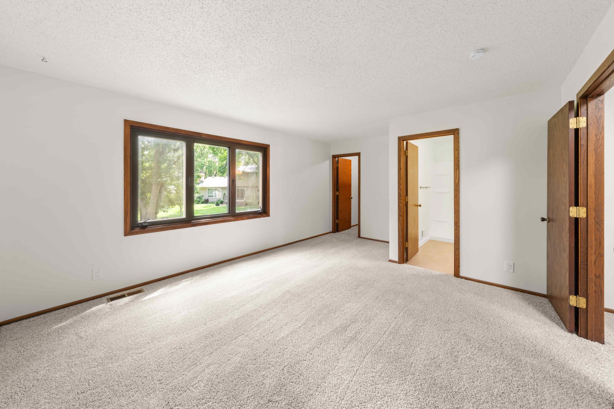 Primary bedroom with abundant natural light, and convenient access to the private bath and walk-in closet