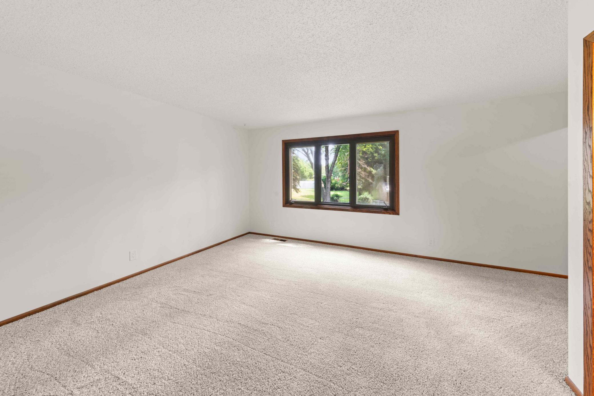 Generously sized owner's suite with fresh neutral finishes, new carpeting and a large window for natural light