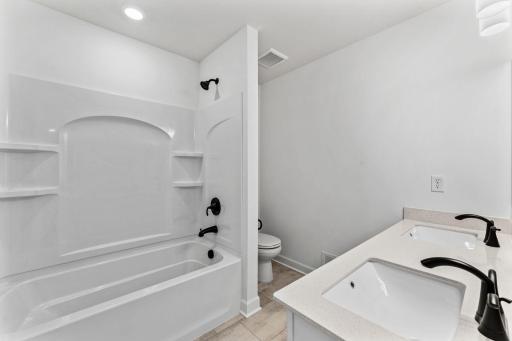 This shared full bathroom includes a full-width vanity mirror and a shower-tub combination.