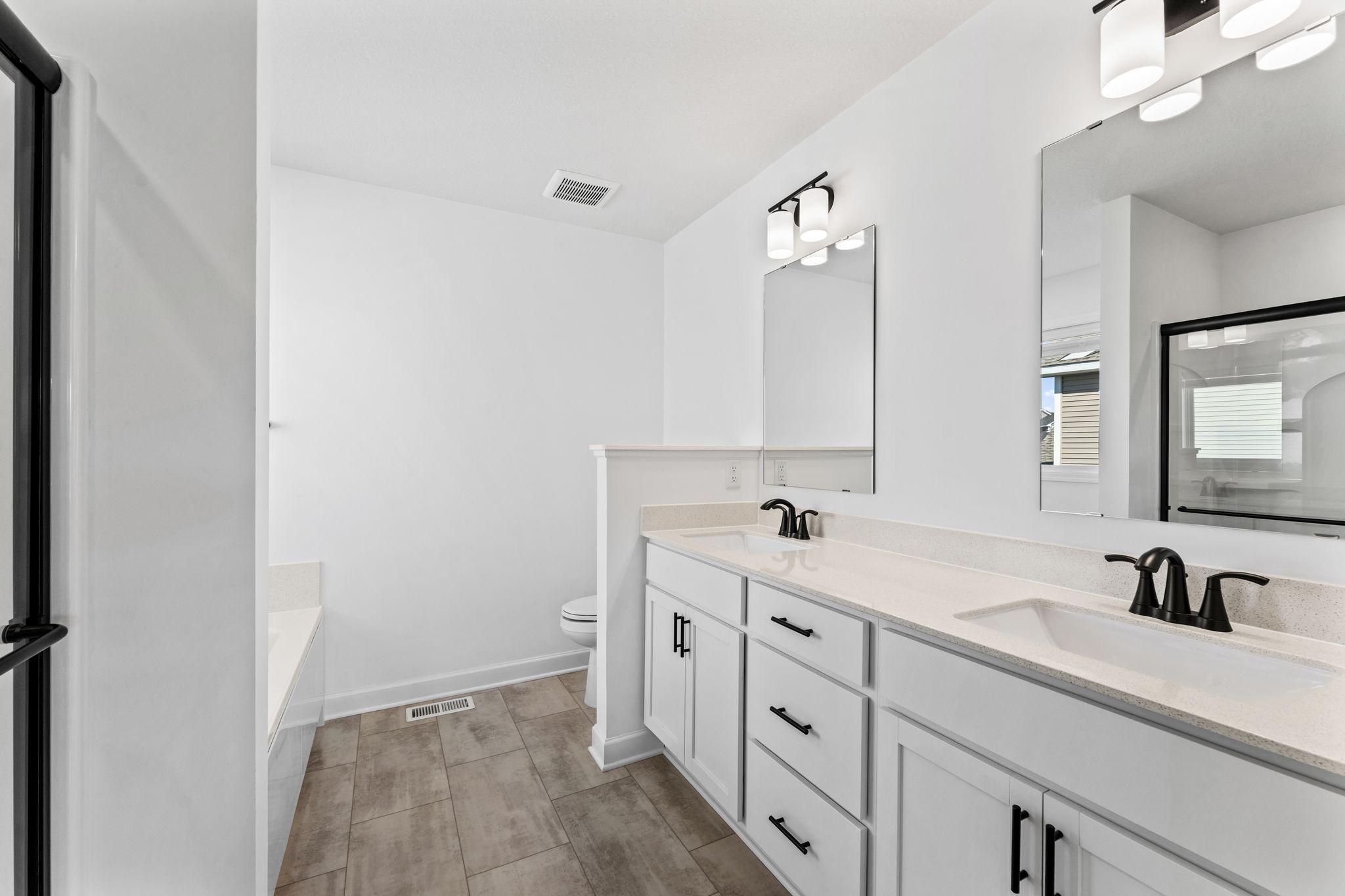 Dual sinks, a glass-enclosed shower and separate soaking tub are included in the en-suite bathroom