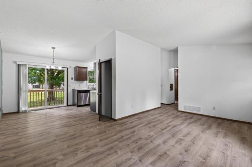 Open living room and dining room with newer vinyl plank flooring