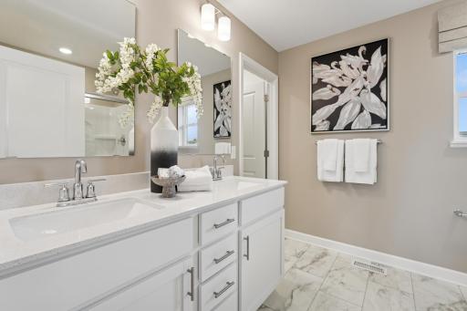 (Photo is of a decorated model, actual homes finishes will vary) An extension of the primary bedroom, this private and spacious bath contains a double-vanity and a large walk in shower.