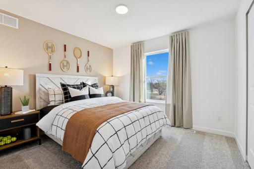 (Photo is of a decorated model, actual homes finishes will vary) One of three generously sized secondary bedrooms with spacious walk-in closets.