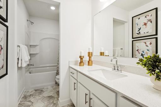 (Photo is of a decorated model, actual homes finishes will vary) Located on the upper level, this secondary bath provides more than enough space! The vanity space has a nice separation from the toilet & shower.
