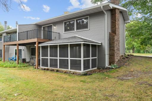 View of the back of the home with screened porch and new maintenance free deck