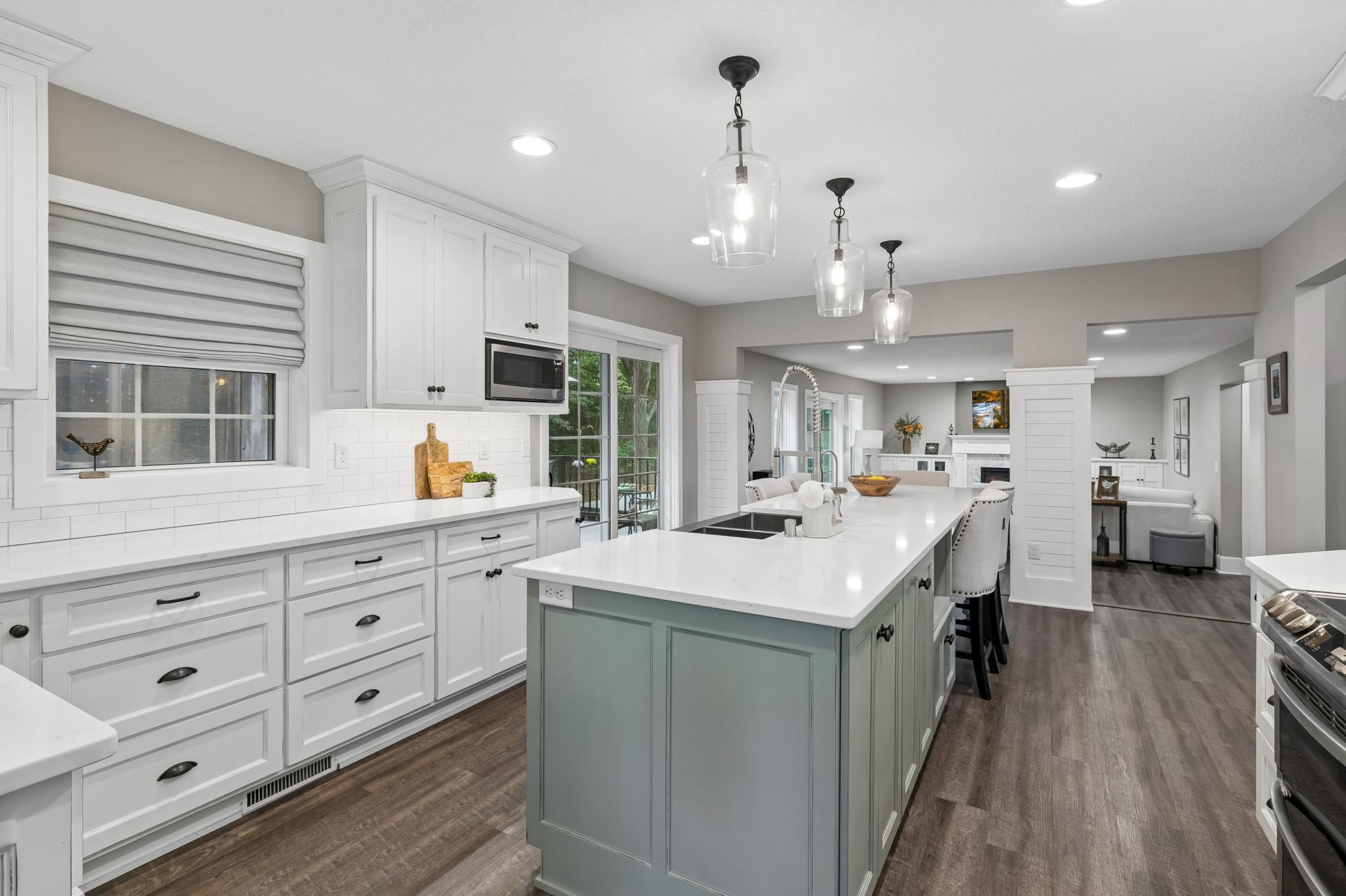 Kitchen featuring custom two-tone cabinetry, generous storage, and a large center island.