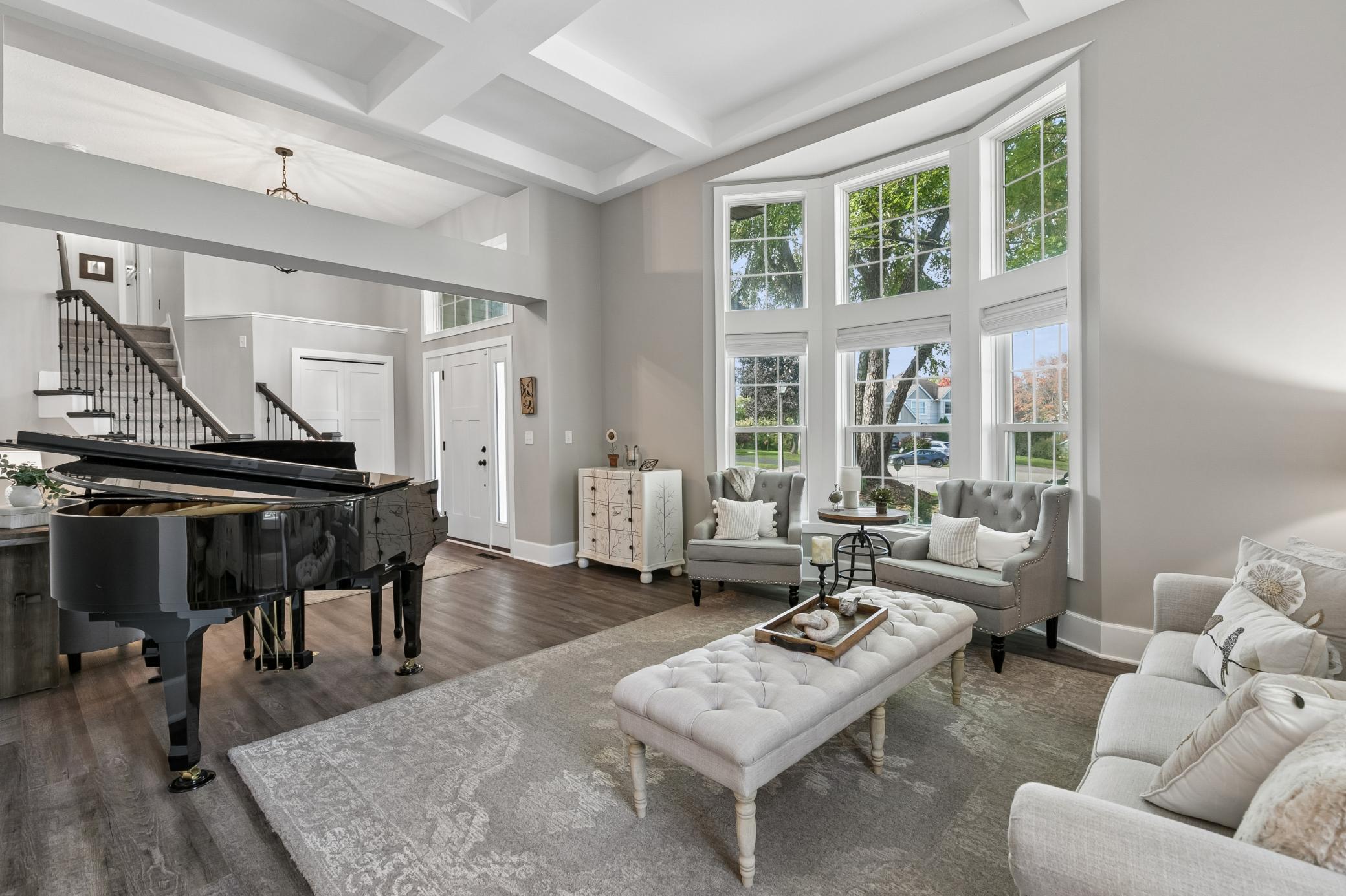 The living room features a dramatic coffered ceiling and plenty of room to gather, relax, and enjoy time with family and friends.